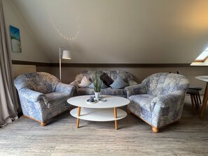 A room with two patterned armchairs, a white coffee table, and a floor lamp. - Jacobihof - Fiete - Jacobihof "Fiete" 3-room apartment near the beach in a quiet (Dahme)