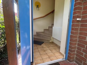 A staircase with a handrail, a radiator, and a doormat. - Jacobihof - Fiete - Jacobihof "Fiete" 3-room apartment near the beach in a quiet (Dahme)