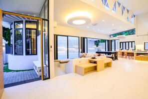 A modern interior with a living area, dining space, and a kitchen. - Modern Spacious 3 beds Pool Villa BA1 (Pattaya)