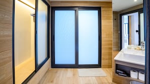 A modern bathroom with a sliding glass door, a white sink, and a wooden floor. - Modern Spacious 3 beds Pool Villa BA1 (Pattaya)