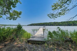 A wooden dock extending into a calm lake, surrounded by dense greenery and trees. - Gilmore Lake Family Escape w/ Game Room & Dock! (Minong)