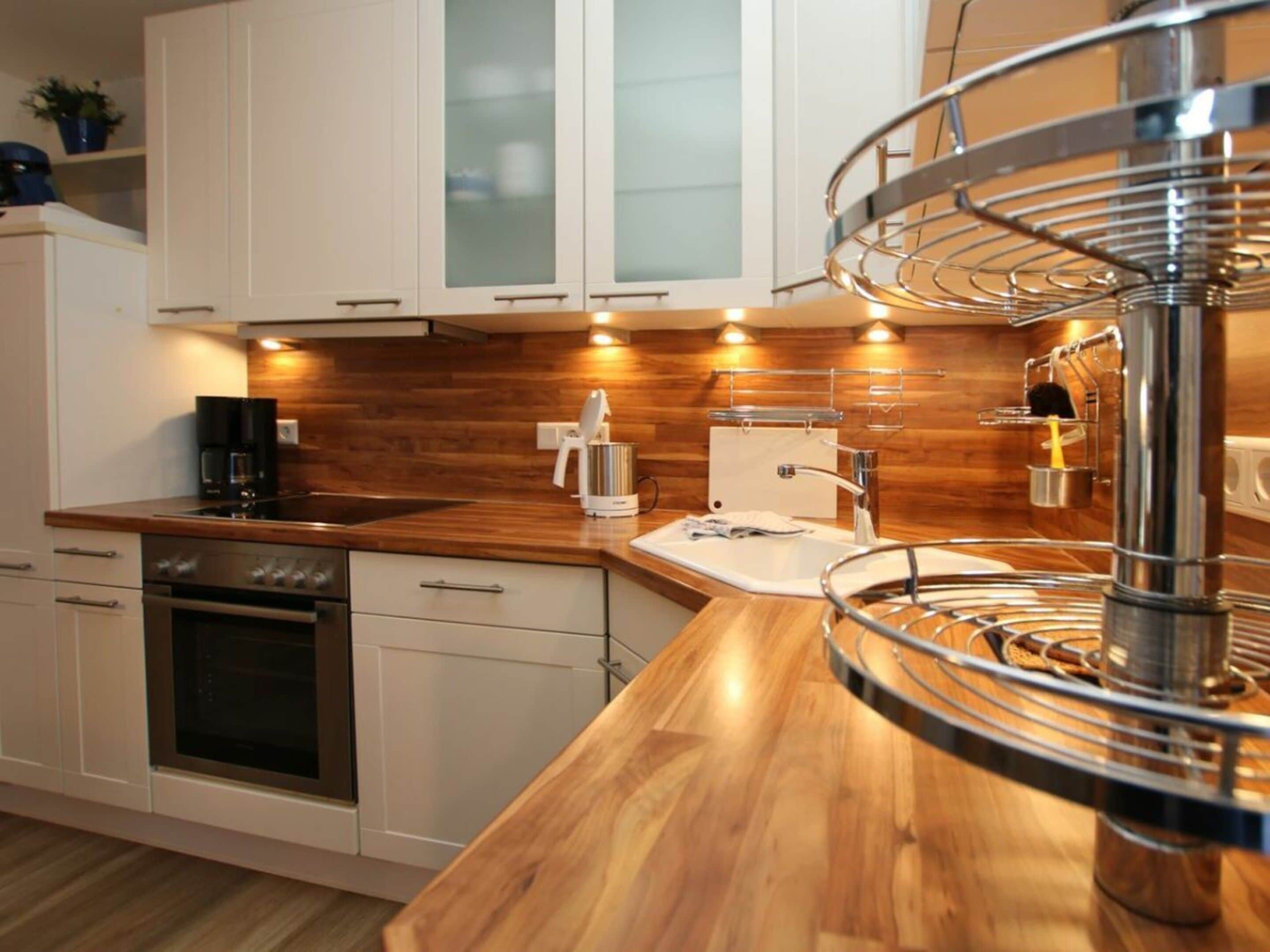 A modern kitchen with wooden countertops, stainless steel appliances, and a built-in oven.