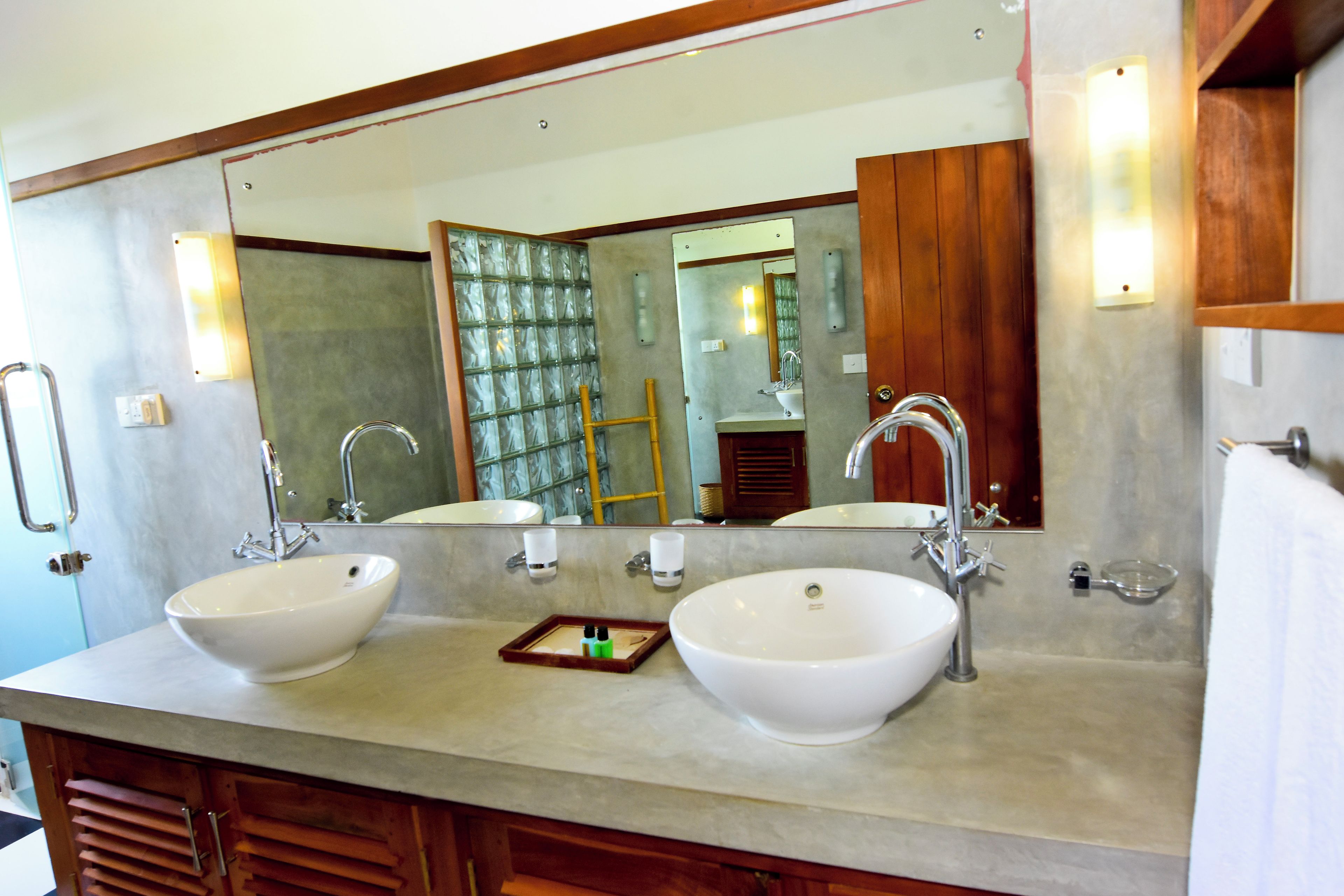 A bathroom with two sinks, a large mirror, and wooden cabinets.