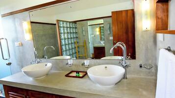 A bathroom with two sinks, a large mirror, and wooden cabinets.