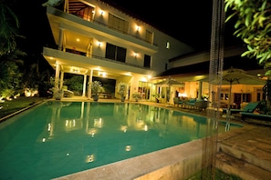 A multi-story hotel with a swimming pool, outdoor seating, and a well-lit entrance. - Hotel with 4 bedrooms and AC in peaceful Negombo (Negombo)