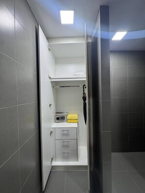 Un bagno compatto con un mobiletto bianco, un portasciuga e una radio.
