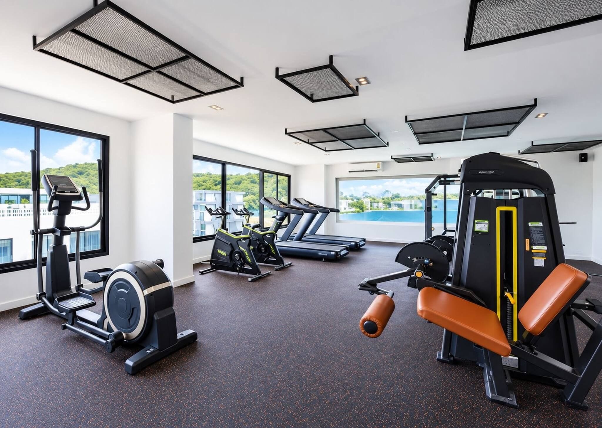 A gym with cardio machines, weight training equipment, and large windows offering views of a cityscape.
