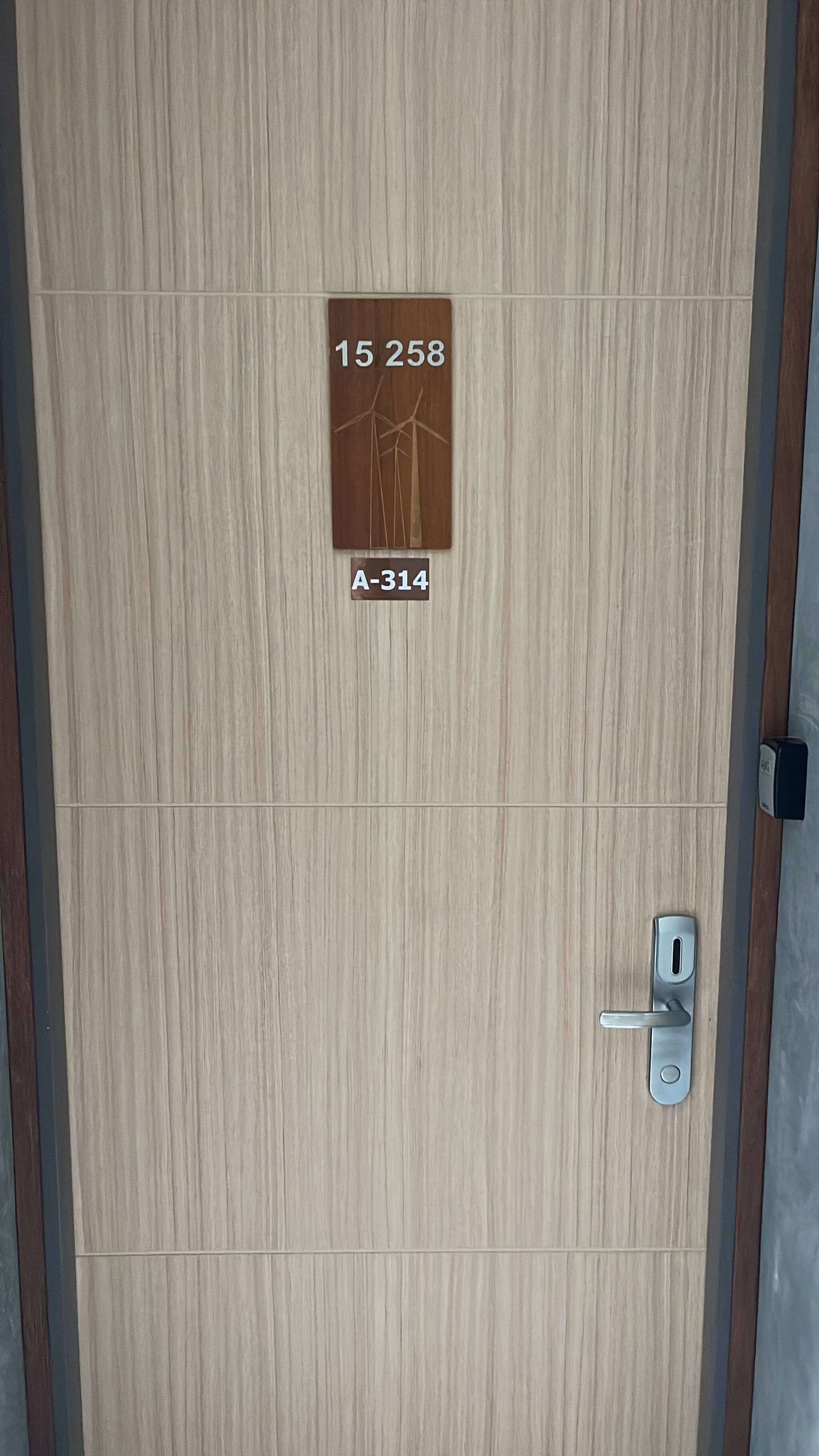 A wooden door with a metal handle and a sign above it.