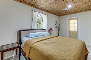 A bedroom with a bed, a nightstand, a window with curtains, a lamp, and a door. - 4 Mi to Lake! Somerville Home w/ Covered Deck (Somerville)