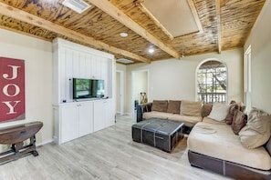 A living room with a television on a cabinet, a sofa, and a window with a view. - 4 Mi to Lake! Somerville Home w/ Covered Deck (Somerville)