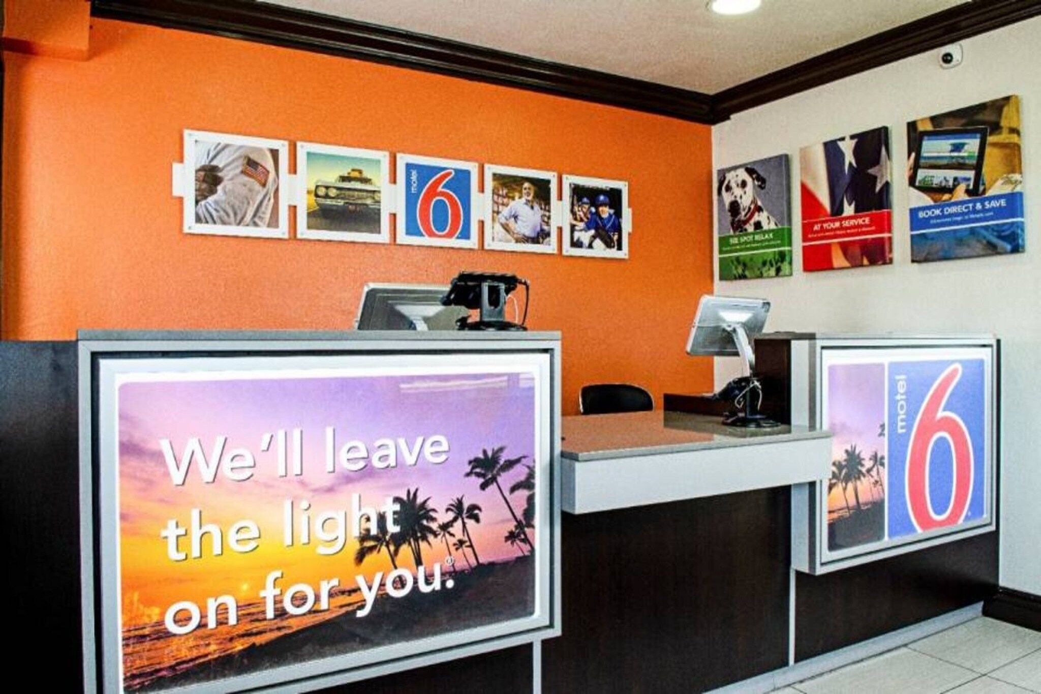 A hotel reception desk with a large sign stating 'We'll leave the light on for you.'