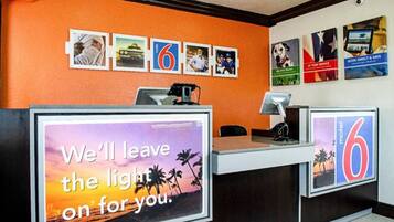 A hotel reception desk with a large sign stating 'We'll leave the light on for you.'