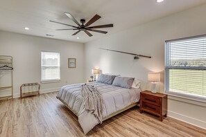 A bedroom with a bed, bedside tables, a ceiling fan, and a window with blinds. - 'River Bank' Spacious Waterfront Group Getaway (Nashville)
