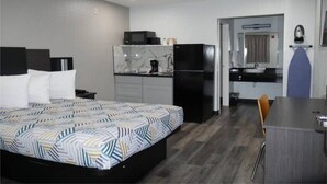 Une chambre d’hôtel comprenant un lit, un bureau, une kitchenette et une salle de bain.