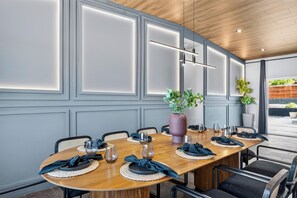 A conference room with a long table, chairs, and a potted plant. - Pool + Spa + Putting Green + Bocce + Fire Pit | Natl Park West Gate | Desert Ace (Joshua Tree)