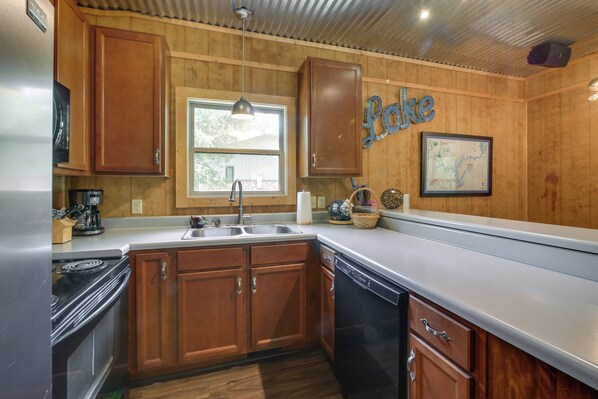 A kitchen with wooden cabinets, a stainless steel sink, and a dishwasher.