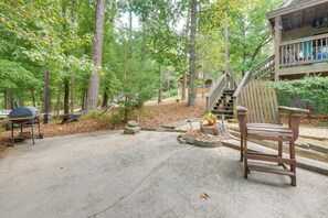 A wooden deck with a bench, a barbecue grill, and a small garden area with a potted plant.