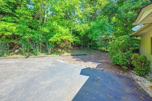 A paved driveway leading to a building with a satellite dish on the roof, surrounded by dense greenery. - Mountain Golf Getaway: 5 Mi to Franklin (Franklin)
