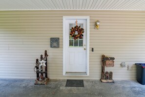 A front door with a wreath, a mailbox, a welcome sign, and a trash can. - Private Yard: Fire Pit & Cornhole! Moorefield Gem (Moorefield)