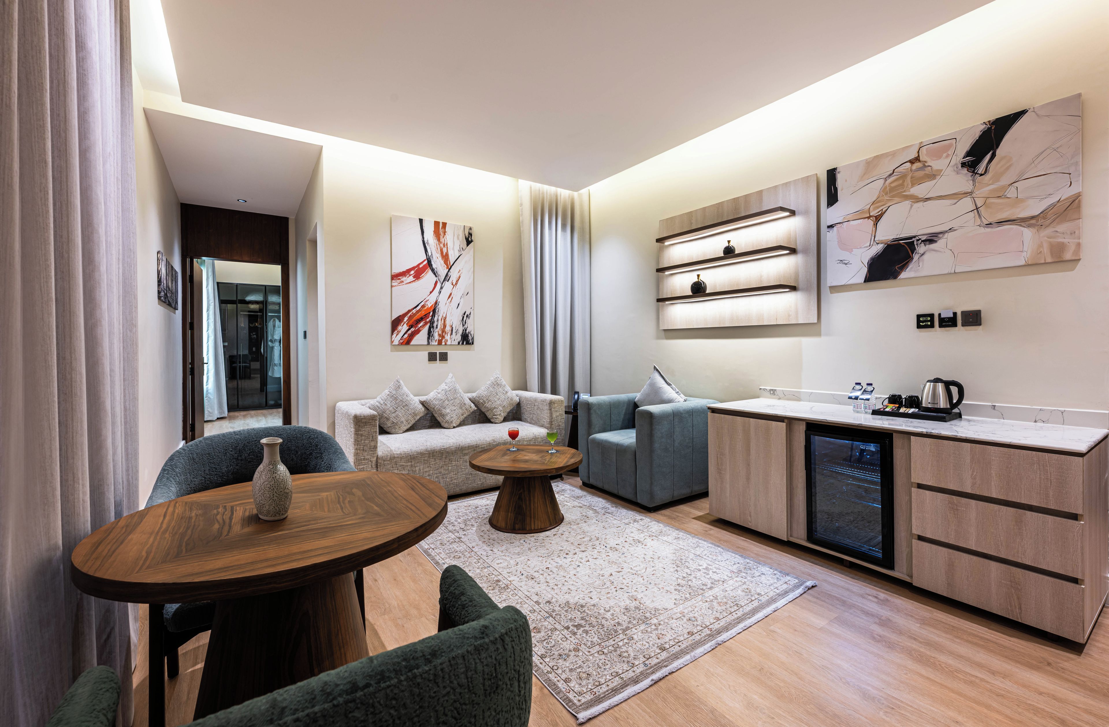 Uma sala de estar moderna com um sofá, mesa de centro e área de jantar com uma pequena mesa e cadeiras.