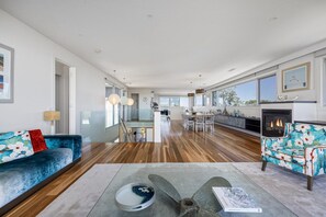 A modern living room with a sofa, a coffee table, and a fireplace. - Stanley House Mt Martha. (Mount Martha)