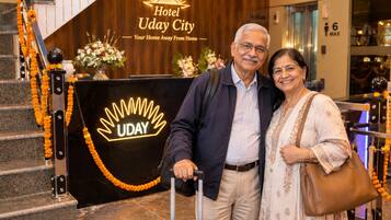 Entrada de hotel con un letrero que dice 'Hotel Uday City' y un logotipo con la palabra 'UDAY'.