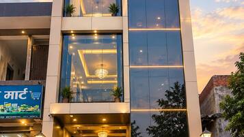 Un hotel con fachada moderna, amplias ventanas y un letrero destacado que dice 'UDAY HOTEL'.