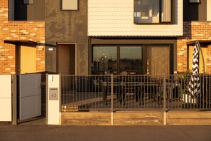 Een gebouw met een bakstenen gevel, een metalen poort en een huisnummer '43'.