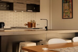 Een moderne keuken met een witte betegelde spatwand, een houten aanrechtblad en een koffieapparaat.