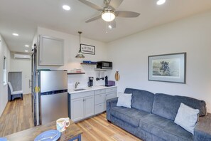 A compact living space with a kitchenette, a gray sofa, and a dining area. - Trail Access & Views! 90-Acre Haven in Hot Springs (Hot Springs)