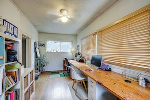 A home office with a desk, computer, and shelving with books and a guide. - Home w/ Office & Yard, 5 Mi to Dtwn Portland! (Portland)