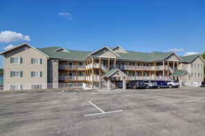 A multi-story hotel with a parking lot in front.