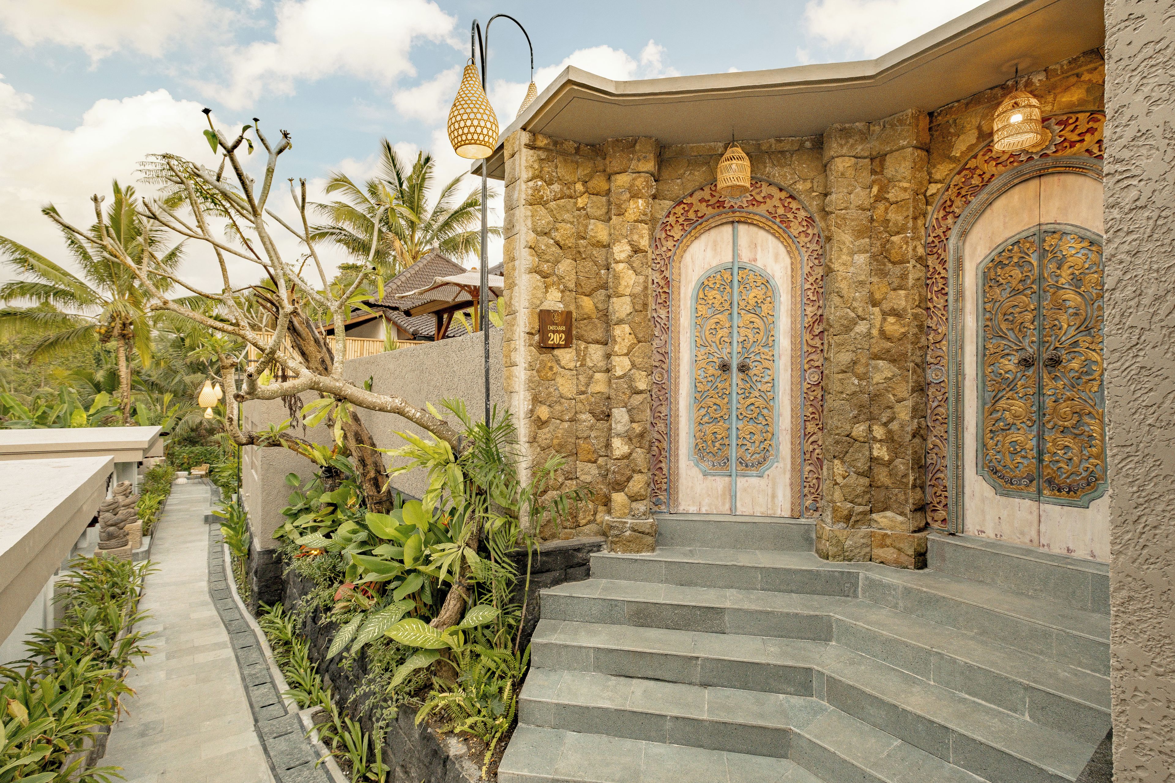 A stone building with ornate doors and a sign indicating room number 202.