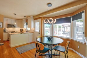 A modern kitchen with white cabinets, a built-in oven, and a dining area with a round table and chairs. - Stylish & Spacious Home w/ Fenced Yard in Richmond (Richmond)