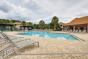 A swimming pool with lounge chairs and a covered seating area. - Gateway to UF & Dtwn Gainesville! Condo w/ Pool (Gainesville)