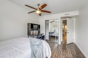 A bedroom with a bed, a desk, a wardrobe, and a ceiling fan. - Gateway to UF & Dtwn Gainesville! Condo w/ Pool (Gainesville)