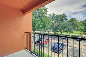 A balcony with a view of a parking lot and trees. - Gateway to UF & Dtwn Gainesville! Condo w/ Pool (Gainesville)