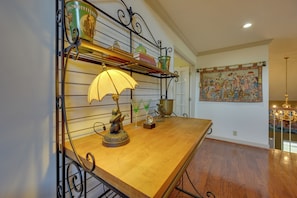 A wooden table with a lamp, decorative items, and a metal shelf with books and a vase. - Luxury, 2 Master Suites, Fire Pit, Kayaks (Milledgeville)