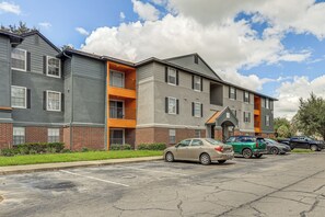 A multi-story apartment building with a parking lot in front. - Work, Explore & Unwind! Condo 2 Mi to UF (Gainesville)