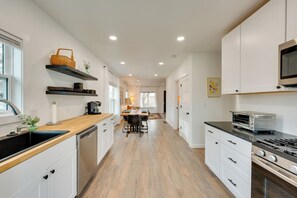 A modern kitchen with white cabinetry, a wooden countertop, a built-in oven, and a microwave. - Spacious Duplex Duo: 14 Mi to Pearl Street Mall (Erie)