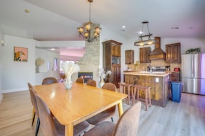 A modern kitchen with a central island, wooden cabinets, and stainless steel appliances. - Home w/ Putting Green, 11 Mi to Las Vegas Strip! (North Las Vegas)