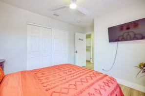 A bedroom with a bed, a ceiling fan, a door, and a wall-mounted television. - Home w/ Putting Green, 11 Mi to Las Vegas Strip! (North Las Vegas)