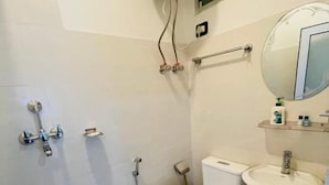A bathroom with a toilet, sink, shower, and a mirror. - Hotel Janakpur Inn (Janakpur)