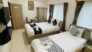 A hotel room with two beds, a TV, a wardrobe, and a ceiling fan. - Hotel Janakpur Inn (Janakpur)