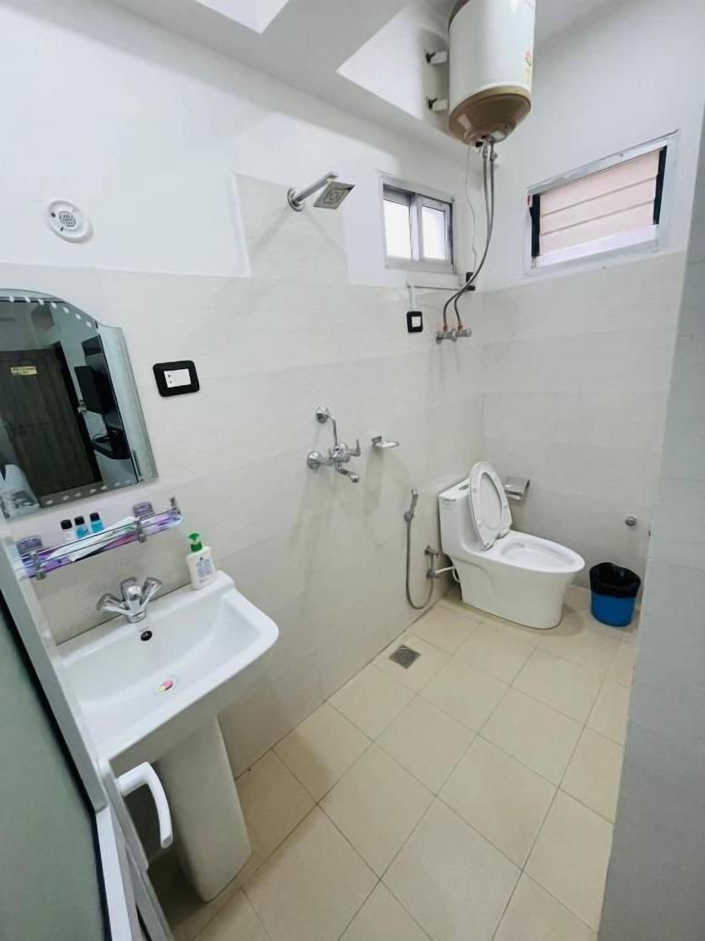 A bathroom with a sink, mirror, toilet, and shower.
