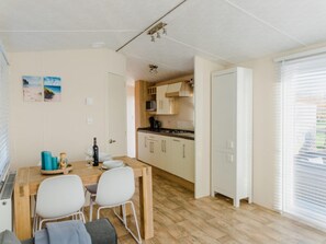 A compact kitchen with white cabinets, a microwave, and a stove.