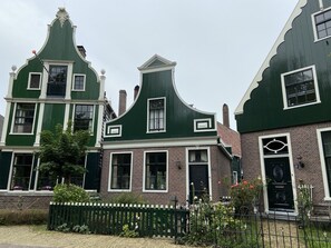 A row of traditional houses with gabled roofs and white trim.