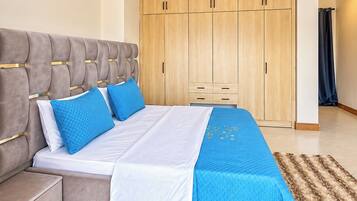 Un dormitorio con cama, mesita de noche, armario y un baño visible al fondo.