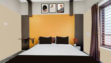 Habitación de hotel con cama, mesita de noche, una pequeña mesa y ventana con cortinas.