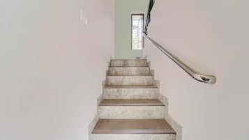 Eine Treppe mit Marmorstufen führt zu einem Raum mit einem Fenster.